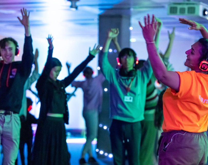 A woman in an orange t-shirt leading a silent disco