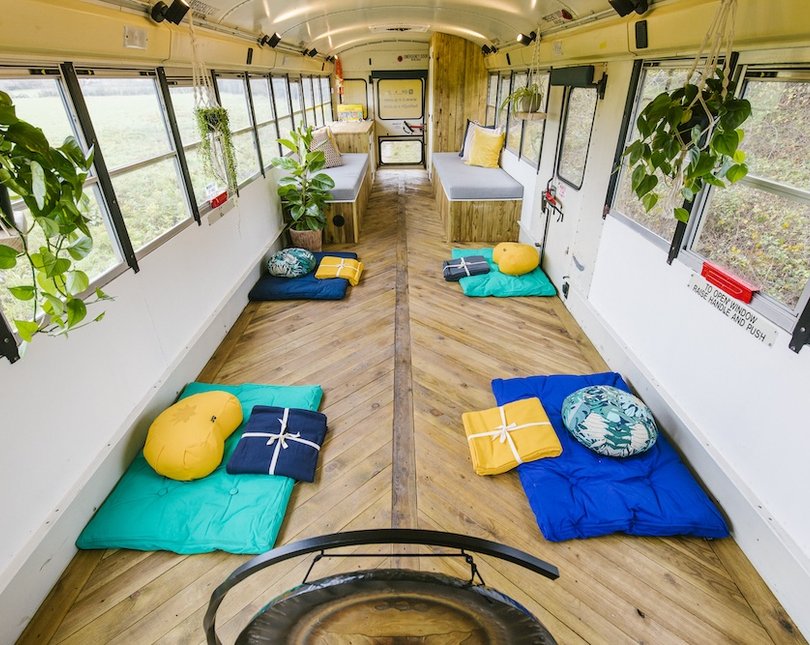 Inside the Zen Bus, a relaxing empty bus with cushions and plants