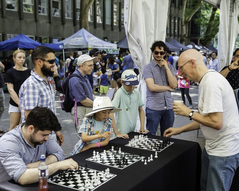A crowd of people playing or watching chess games