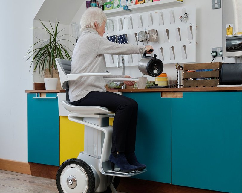 Woman making tea in robotic chair