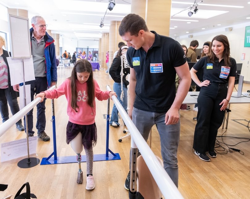 A young girl trying out a prosthetic leg