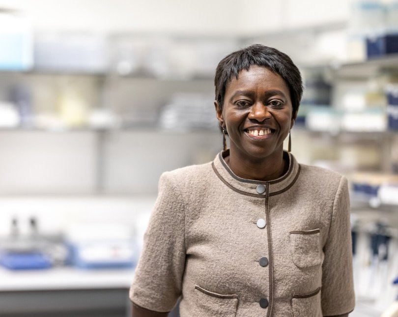 Professor Faith Osier in a lab smiling at the camera