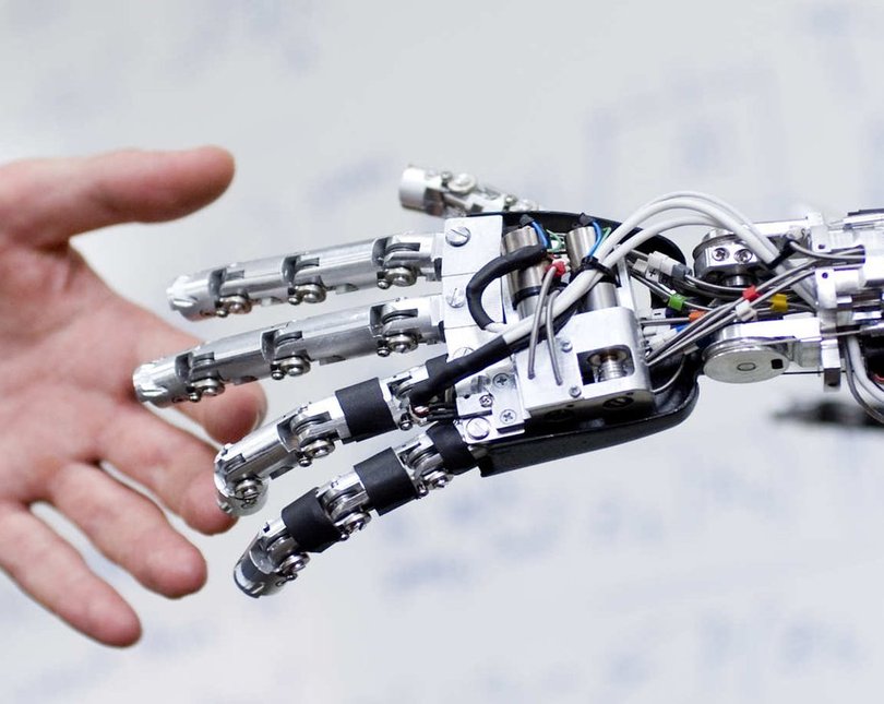 A robotic hand holding human hand