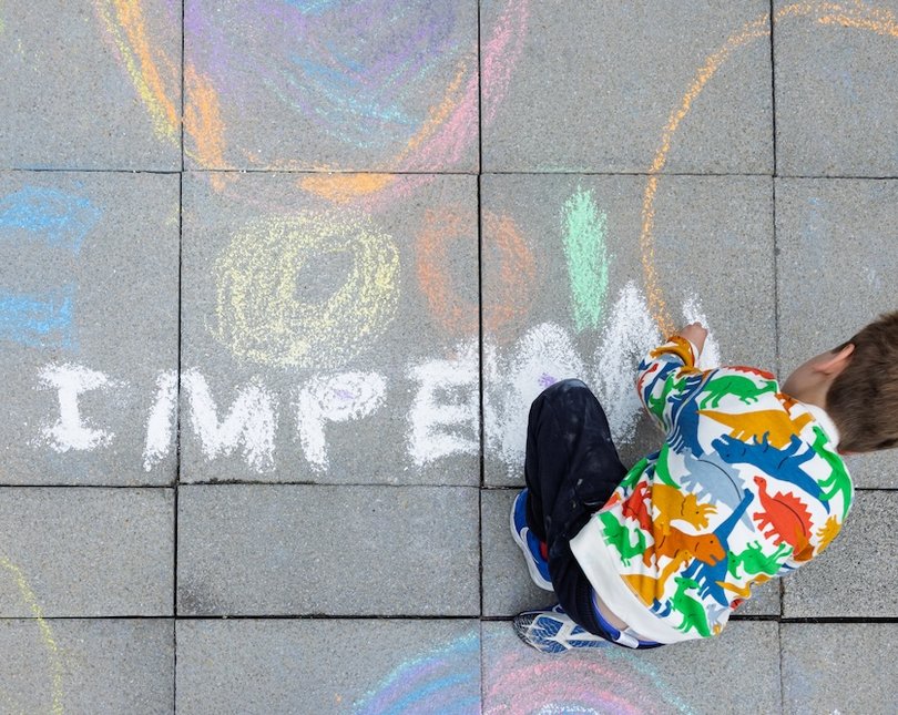 Aerial view of a boy drawing with chalk on concrete