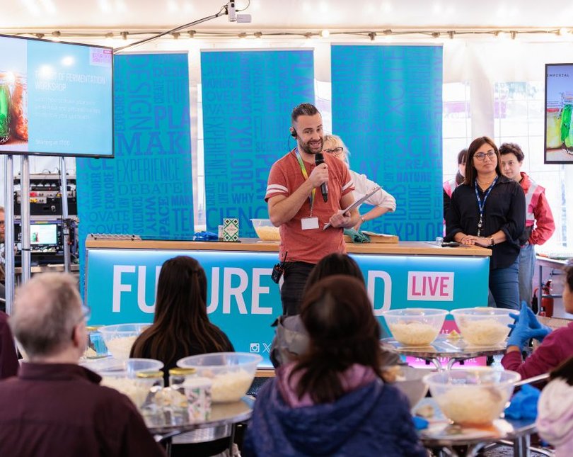Man speaks to people taking part in food workshop