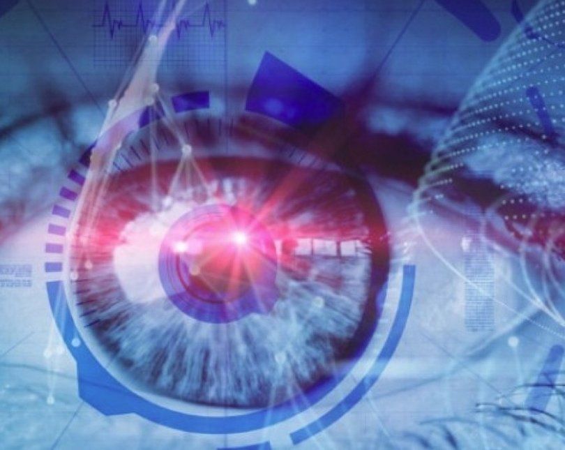 Blue tinted close up photo of an eye with a red light shining out of the pupil