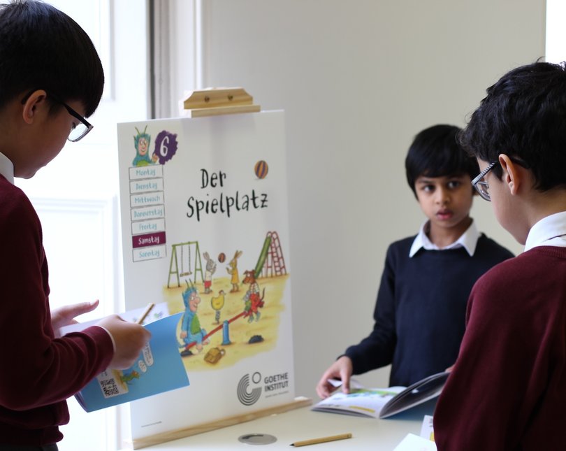 Young school boys looking at a poster with a children's illustration
