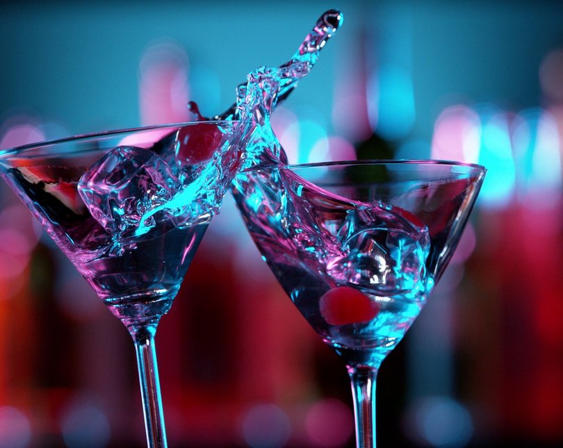 Two martini glasses, with liquid splashing
