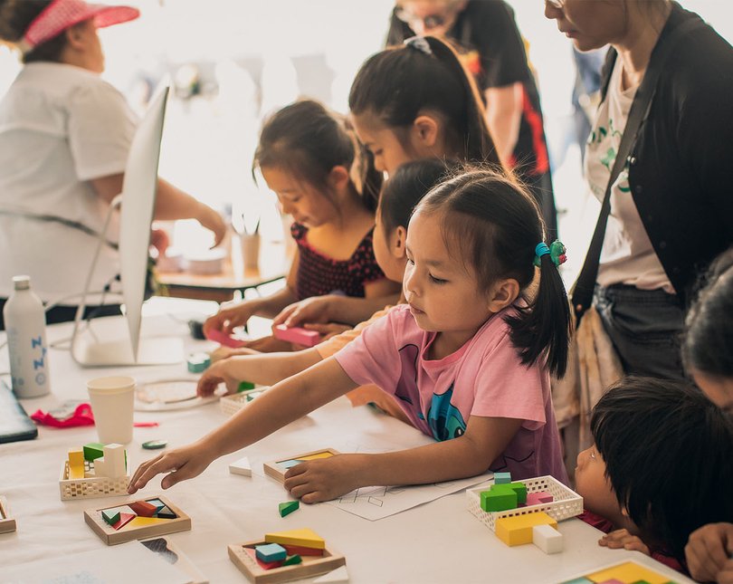 A group of children engaging with an exhibit