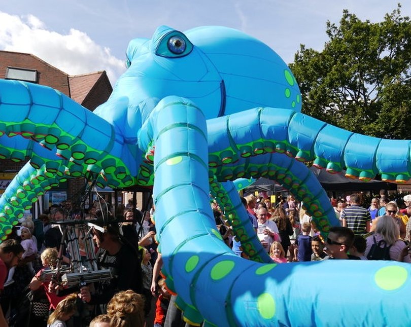 Large blow up blue octopus with crowds around