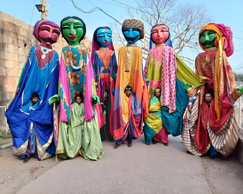 Giant colourful puppets of people standing together