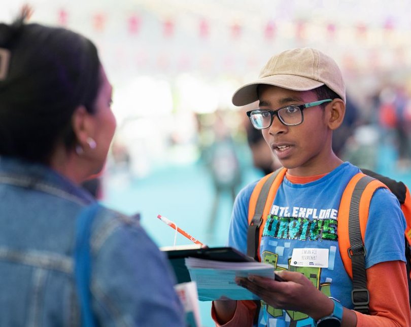 Boy with clipboard asking woman questions