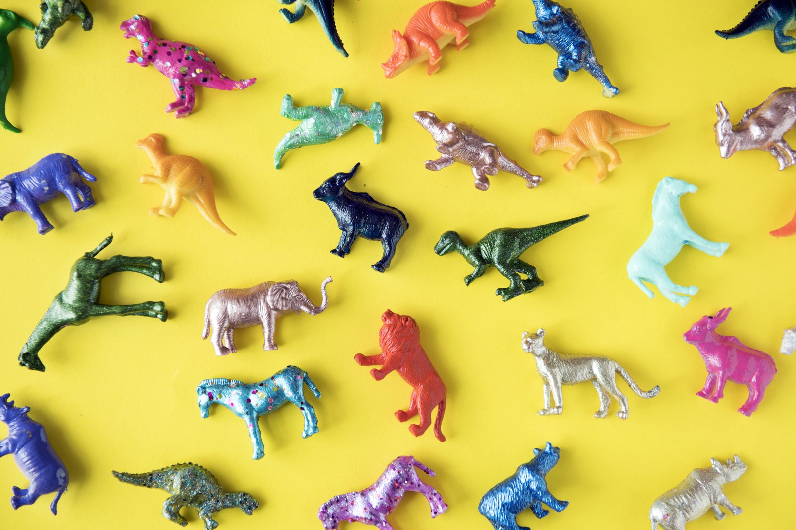 Toy animals and dinosaurs on yellow background